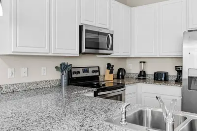 a kitchen with white cabinets and a stainless steel appliances at Amazing 4 Bedrooms- Near Disney in Kissimmee