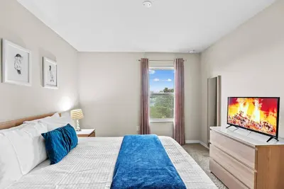 a bedroom with a bed and a flat screen tv at Amazing 4 Bedrooms- Near Disney in Kissimmee