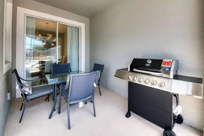 a kitchen with a table and a desk with a laptop at Casa c/ piscina privativa a 10 min da Disney in Kissimmee