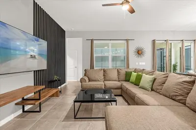 a living room with a couch and a tv at Upstay Bella Vida Resort - Resort-Style 12BR Villa in Kissimmee