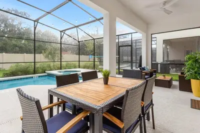 a dining room with a table and chairs and a swimming pool at Upstay Bella Vida Resort - Resort-Style 12BR Villa in Kissimmee