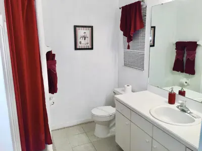 a bathroom with a white toilet and a sink at Plutospad in Orlando