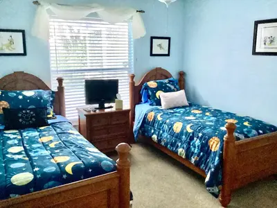 a bedroom with two beds and a television in it at Plutospad in Orlando