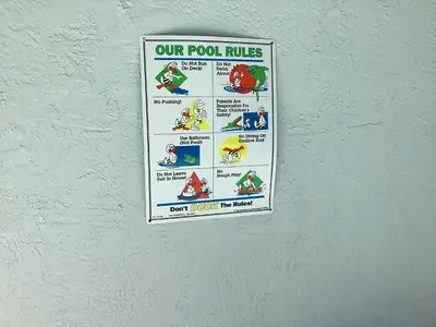 a sign on a wall that reads our pool rules at Plutospad in Orlando