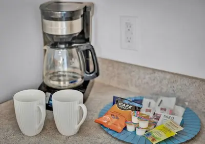a counter with a coffee maker and two cups on it at Spacious Emerald Home - Pool and Lanai Near Disney in Kissimmee