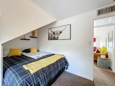a bedroom with a bed and a picture of a bull on the wall at 1920s Rustic Cabin, 20 Min to Disney and Nightlife in Orlando
