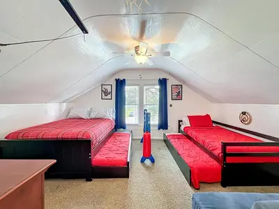 a room with two beds with red cushions and a ceiling at 1920s Rustic Cabin, 20 Min to Disney and Nightlife in Orlando
