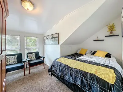 a bedroom with a bed and two chairs at 1920s Rustic Cabin, 20 Min to Disney and Nightlife in Orlando