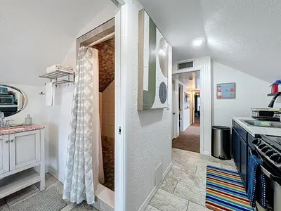 a kitchen with a door leading to a hallway at 1920s Rustic Cabin, 20 Min to Disney and Nightlife in Orlando
