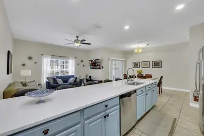 a kitchen with a white counter top and a living room at Resort Fun Star Wars Toy Story Rooms Near Disney in Kissimmee