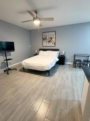 a bedroom with a bed and a flat screen tv at Cozy Modern Studio in Orlando