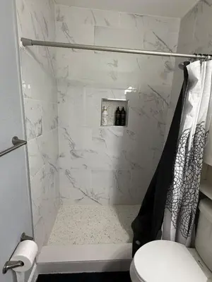 a white bathroom with a shower with a toilet at Cozy Modern Studio in Orlando