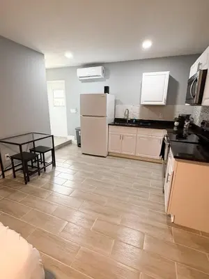 a kitchen and dining room with a table and refrigerator at Cozy Modern Studio in Orlando