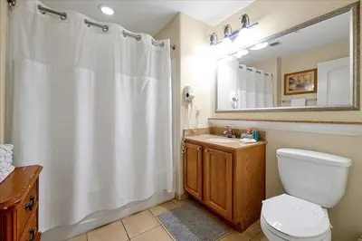 a bathroom with a white shower curtain and a toilet at Luxurious Condo near DisneyLand in Orlando