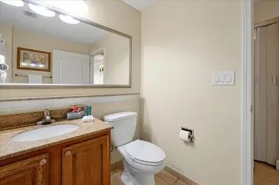 a bathroom with a toilet and a sink and a mirror at Luxurious Condo near DisneyLand in Orlando