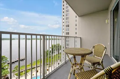 a balcony with a table and chairs and a view of the water at Luxurious Condo near DisneyLand in Orlando