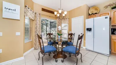 a dining room with a table and chairs and a refrigerator at MNL2696 in Orlando