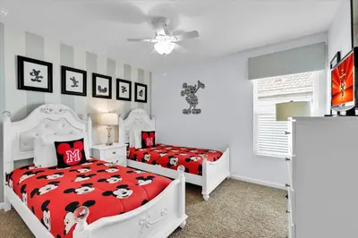two beds in a bedroom with red and white at AF2574 - Windsor Hills Resort Vacation Home in Orlando