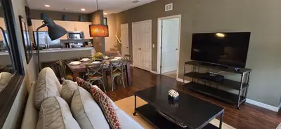 a living room with a couch and a table and a television at 3BR Townhome West Lucaya Resort Close to Disney in Kissimmee