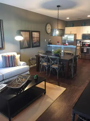 a living room with a couch and a table and a kitchen at 3BR Townhome West Lucaya Resort Close to Disney in Kissimmee