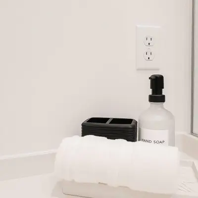 a bottle of hand soap next to a black appliance at Beauty 4 miles to Disney 3Br 2Ba Pool Home in Kissimmee