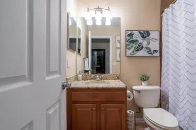 a bathroom with a sink and a toilet and a mirror at Large 3 bedroom with King Bed in Orlando