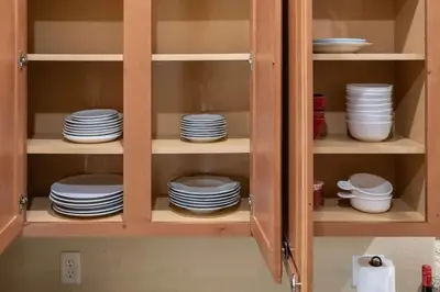 a cabinet filled with plates and dishes in it at Large 3 bedroom with King Bed in Orlando