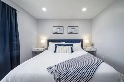 a bedroom with a large white bed with two night stands at Large 2 bedroom with King bed and Patio in Orlando