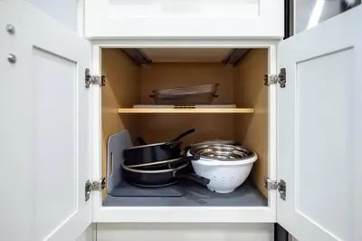 a cupboard with some pots and pans in it at Large 2 bedroom with King bed and Patio in Orlando