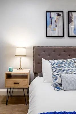 a bedroom with a bed and a nightstand with a lamp at Large 2 bedroom with King bed and Patio in Orlando