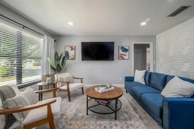 a living room with a blue couch and a table at Large 2 bedroom with King bed and Patio in Orlando