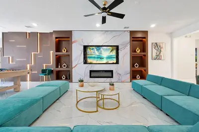 a living room with blue couches and a tv at Luxury and Sophisticated 15 BR ensuite in Kissimmee