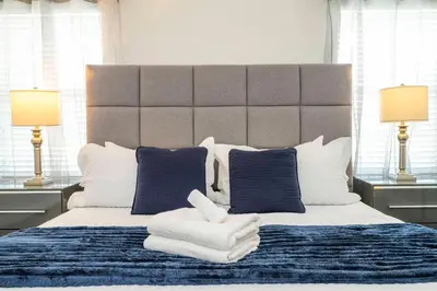 a bedroom with a large bed with blue and white pillows at Beautiful 4 BR close to Disney in Kissimmee