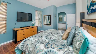 a blue bedroom with a bed and a tv at FP8157 - Windsor Palms Resort 4 Bedroom Home With Game Room in Kissimmee