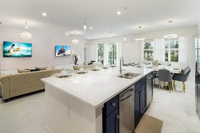 a kitchen and living room with a sink and a couch at Upstay 15BR Villa w Games Room, Pool & Cinema in Kissimmee