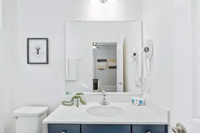 a white bathroom with a sink and a mirror at Upstay 15BR Villa w Games Room, Pool & Cinema in Kissimmee