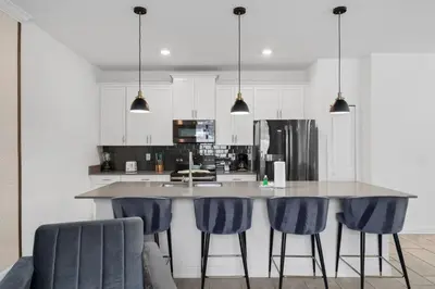 a kitchen with a large island with blue bar stools at Refúgio Incrível a 10 Min da Disney – Storey Lake in Kissimmee