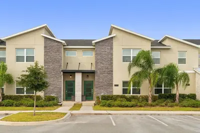 a large apartment building with palm trees in a parking lot at Refúgio Incrível a 10 Min da Disney – Storey Lake in Kissimmee