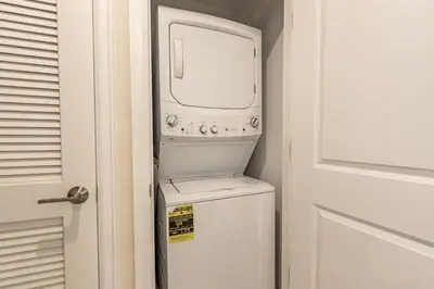 a washer and dryer in a bathroom next to a door at Comfortable 2BR Condo w Lake Views in Kissimmee