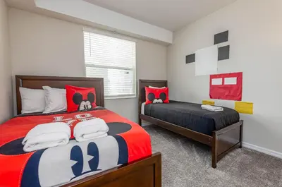 a bedroom with two beds and a dog on the bed at Comfortable 2BR Condo w Lake Views in Kissimmee