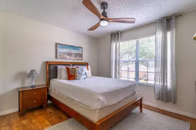 a bedroom with a bed with a ceiling fan and a window at 8512 Emerald Island in Kissimmee