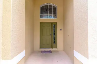 a green door in a building with a window at 8512 Emerald Island in Kissimmee