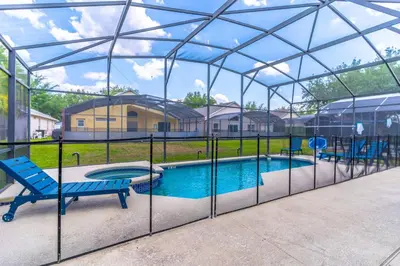 a pool in a glass enclosure with a bench next to it at 8512 Emerald Island in Kissimmee
