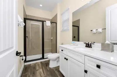 a white bathroom with a toilet and a sink at Coral Cottage With Private Pool Near Disney With Margaritaville Resort And Island H20 Waterpark Access - 2946Sr in Orlando