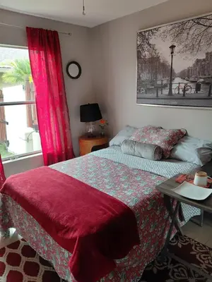 a bedroom with a bed with a red blanket and a window at COZY BRIGHT SINGLE Room in Orlando