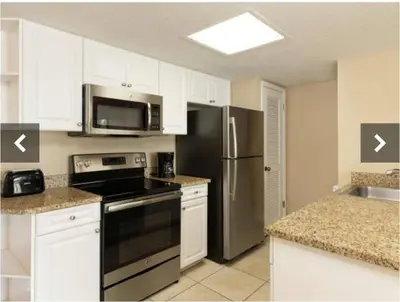 a kitchen with stainless steel appliances and white cabinets at Westgate Towers in Orlando