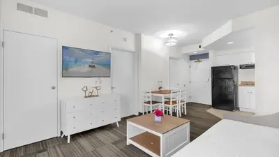 a white living room with a kitchen and a table at Condo with Hot Tub and Pool in Orlando
