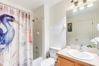 a bathroom with a shower curtain with a blue bird on it at 3 Mi to Disney World Poolside Oasis with Game Room in Kissimmee