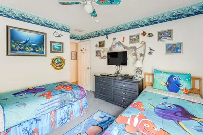 a bedroom with two beds and a tv in it at 3 Mi to Disney World Poolside Oasis with Game Room in Kissimmee
