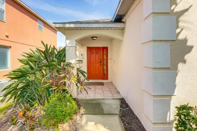 a red door on a house with a walkway at 3 Mi to Disney World Poolside Oasis with Game Room in Kissimmee
